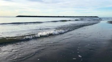 Yavaş hareket eden dalgalar kuma vuruyor, sabahları deniz, dalgalar ve sakin rüzgar.