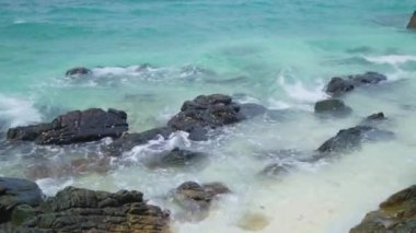 Sea landscape with rocks on the beach Beautiful blue water with waves