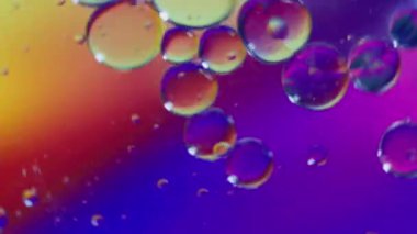 Yağ baloncukları ve küreler renk arkaplanlı su üzerinde hareket ediyorlar, Makro fotoğrafçılık kavramı