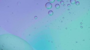 Yağ baloncukları ve küreler renk arkaplanlı su üzerinde hareket ediyorlar, Makro fotoğrafçılık kavramı