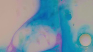 Süt, yağ ve sıvı makro zemin üzerinde hareket eden renkli akrilik boya baloncuklarının üst görünümü.