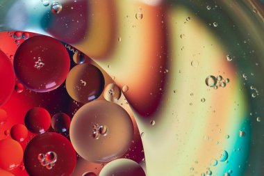 Üst görünüm yağ kabarcıkları renkli arka plan ile suya düşer, Makro fotoğrafçılık konsepti