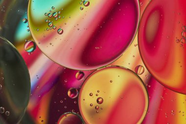Üst görünüm yağ kabarcıkları renkli arka plan ile suya düşer, Makro fotoğrafçılık konsepti