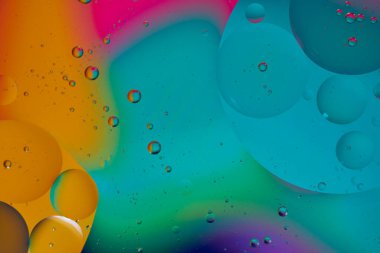 Üst görünüm yağ kabarcıkları renkli arka plan ile suya düşer, Makro fotoğrafçılık konsepti