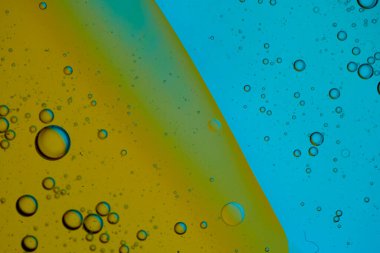 Üst görünüm yağ kabarcıkları renkli arka plan ile suya düşer, Makro fotoğrafçılık konsepti