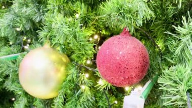Kapalı mekan Noel ağacına yakın çekim top süslemesi. Yanıp sönen bir ışık var..