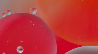 Üst görünüm yağ baloncukları renkli arka plan ile suya düşer, Makro kozmetik konsepti