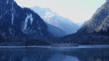 Arka planda karlı dağlar olan göl manzarası. Çin 'deki Bipenggou Milli Parkı
