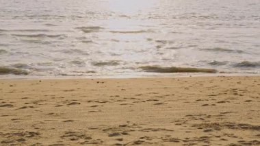 Turistlerin ayak izleri ve Jomtien Sahili 'nin küçük dalgalarıyla dolu deniz, Pattaya' da akşam..