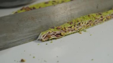 cut fresh Turkish delight with crushed pistachios and chocolate, fresh Turkish delight with green pistachios cut with a knife. 