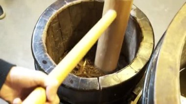 Super slow motion of hitting mortar pestle on pepper seeds. 