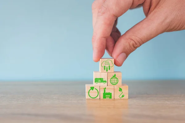 stock image Carbon neutral concept. Net zero greenhouse gas emissions target. Climate neutral long term strategy. Stacking wooden cubes with green net zero and save world icon on grey background.