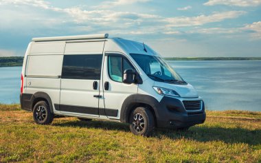 Tepedeki beyaz karavan Çimen ve gökyüzü deniz manzaralı