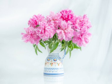 Vazodaki pembe şakayık buketini yüksek anahtarlı masada görmek