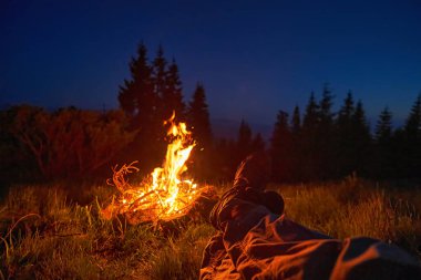 Karanlığı aydınlatan, ağaçlarla çevrili huzurlu bir kamp sahnesi. Macera, açık hava aktiviteleri ve doğada rahatlama konuları için mükemmel..
