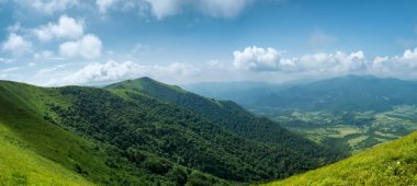 Güneşli bir yaz gününde yeşil tepelerin manzarası