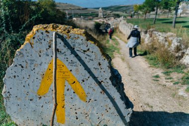 St.James Hac Yolu üzerindeki Galiçya 'nın Sarria İlkbahar Alanı' nda Scallop Shell Sembolü ve Sarı Ok İşaretli Taş Posta. Camino de Santiago Yolu..