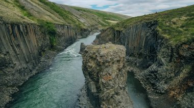 Studlagil Kanyonu 'nda fantastik bir yaz günbatımı. Jokulsa Bru nehrinin inanılmaz akşam manzarası. Yüksek kalite fotoğraf