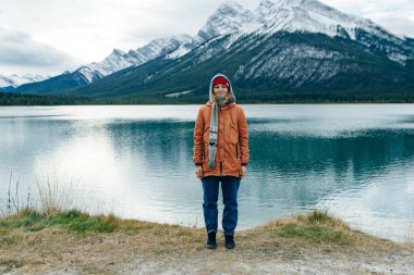 İzleyiciye sırtını dönmüş, Kanada 'daki dağların arasında duran bir kız. Yüksek kalite fotoğraf