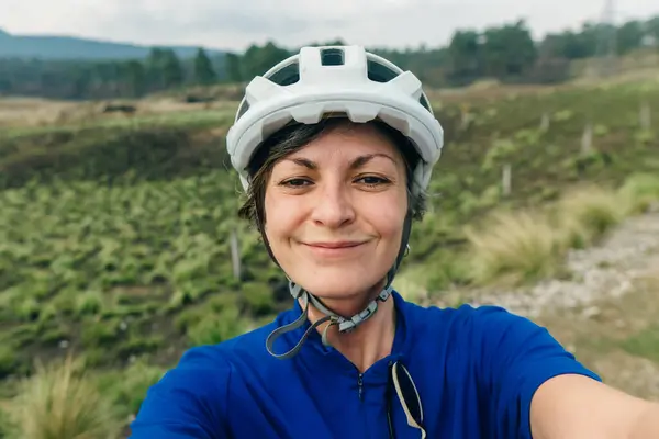 Happy cyclist wearing helmet taking a selfie. High quality photo