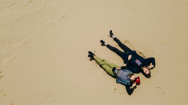 İki kız kumda yatıyor. Yukarıdan bak. Yüksek kalite fotoğraf