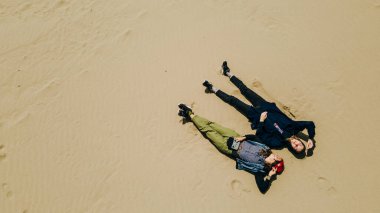 İki kız kumda yatıyor. Yukarıdan bak. Yüksek kalite fotoğraf