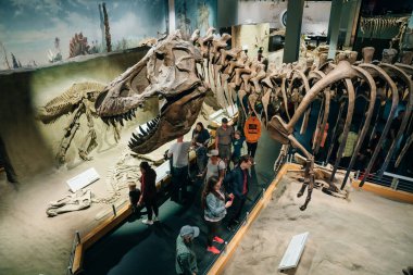 Drumheller, Kanada - Mar 2023 Ziyaretçiler Royal Tyrrell Müzesi 'nin girişindeki dinozor sergilerine akın ediyor. Yüksek kalite fotoğraf