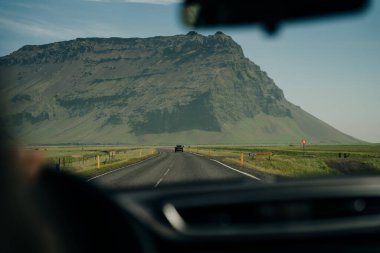 İzlanda 'da araba kullanmak, dağlarla dolu uzun bir yol. Yüksek kalite fotoğraf