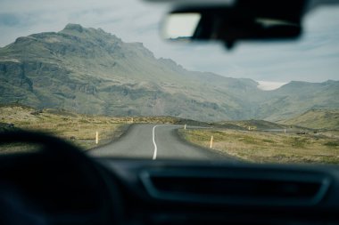 İzlanda 'da araba kullanmak, dağlarla dolu uzun bir yol. Yüksek kalite fotoğraf