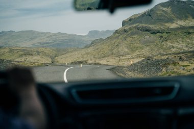 İzlanda 'da araba kullanmak, dağlarla dolu uzun bir yol. Yüksek kalite fotoğraf