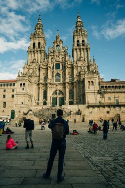 Backpackers and pilgrims looking at Santiago de Compostela Cathedral standing on the Obradeiro square. High quality photo
