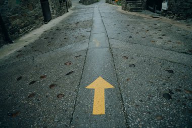 Sarı ok yolda boyanmış. Saint James Yolu 'ndaki hacılar için yön işareti. Camino de Santiago, Galiçya, İspanya. Yüksek kalite fotoğraf