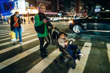 New York, ABD - 12 Eylül 2023 yaya geçidinde bebek arabasıyla gezen genç bir anne. Yüksek kalite fotoğraf