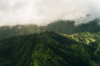 Helikopterden görüldüğü gibi kauai dağlarının etrafında dönen bulutlar. Yüksek kalite fotoğraf