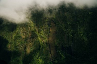 Helikopterden görüldüğü gibi kauai dağlarının etrafında dönen bulutlar. Yüksek kalite fotoğraf