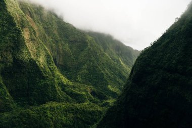 Helikopterden görüldüğü gibi kauai dağlarının etrafında dönen bulutlar. Yüksek kalite fotoğraf