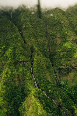 Helikopterden görüldüğü gibi kauai dağlarının etrafında dönen bulutlar. Yüksek kalite fotoğraf
