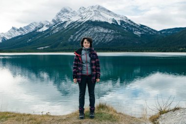 İzleyiciye sırtını dönmüş, Kanada 'daki dağların arasında duran bir kız. Yüksek kalite fotoğraf