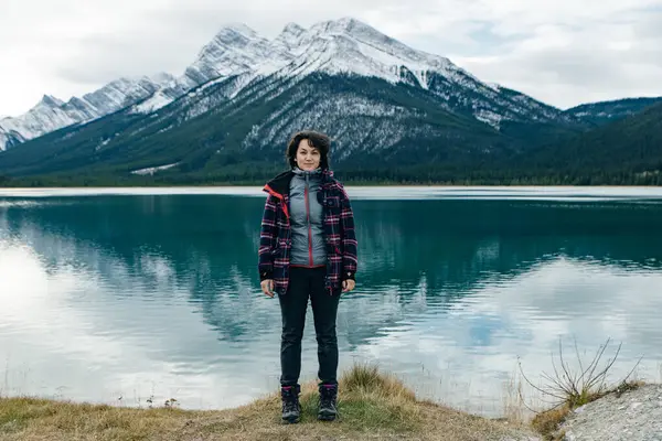 İzleyiciye sırtını dönmüş, Kanada 'daki dağların arasında duran bir kız. Yüksek kalite fotoğraf