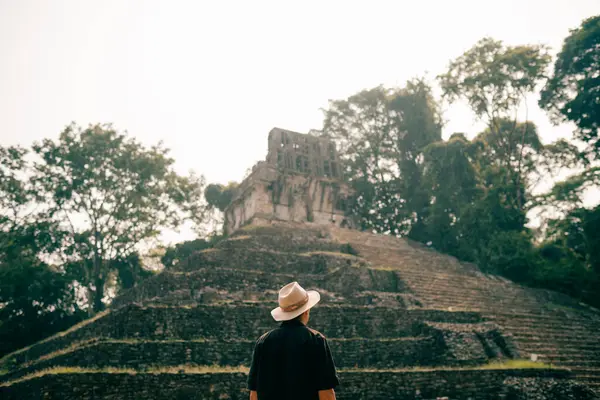 Eski Maya harabelerine bakan şapkalı bir yürüyüşçü. Yüksek kalite fotoğraf