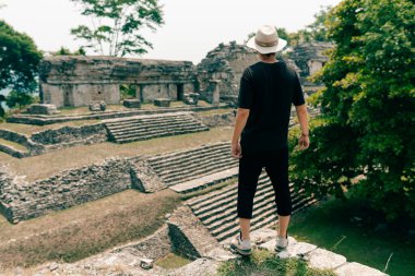 Eski Maya harabelerine bakan şapkalı bir yürüyüşçü. Yüksek kalite fotoğraf