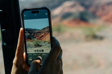 Bir turist, turist otobüsünden dağların fotoğraflarını çekiyor. Yüksek kalite fotoğraf