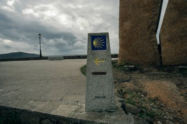 St.James Hac Yolu üzerindeki Galiçya 'nın Sarria İlkbahar Alanı' nda Scallop Shell Sembolü ve Sarı Ok İşaretli Taş Posta. Camino de Santiago Yolu..