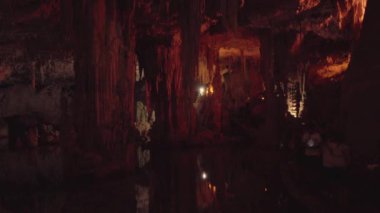 Alghero, İtalya - 1 Mayıs 2024 Neptunes Grotto 'yu ziyaret eden turistler sarkıtlarla dolu bir mağarayı geziyorlar. Yüksek kalite 4k görüntü
