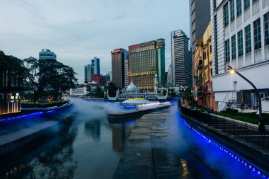 Kuala Lumpur, Malezya - 22 Temmuz 2024 Jamek Camii ve Klang ve Gombak Nehri 'nin birleştiği yerdeki Kolam Biru çeşmesinin muhteşem akşam manzarası. Yüksek kalite fotoğraf