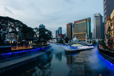 Kuala Lumpur, Malezya - 22 Temmuz 2024 Jamek Camii ve Klang ve Gombak Nehri 'nin birleştiği yerdeki Kolam Biru çeşmesinin muhteşem akşam manzarası. Yüksek kalite fotoğraf