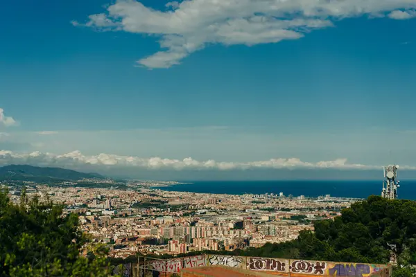 stock image people look at the view of the city from the Bunkers del Carmel on a clear sky in Barcelona, Spain - may 2 2024. High quality photo