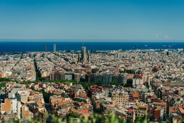 stock image people look at the view of the city from the Bunkers del Carmel on a clear sky in Barcelona, Spain - may 2 2024. High quality photo