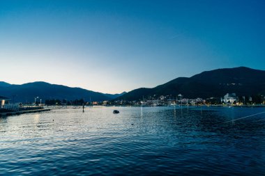 Tivat, Karadağ - 23 Ağustos 2023: Geceleri tatil köyü açıklarında demirli motorlu tekneler. Yüksek kalite fotoğraf