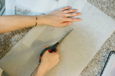 Pişirme tepsisini kağıdıyla doldur ve rulo makasıyla kes. Yüksek kalite fotoğraf